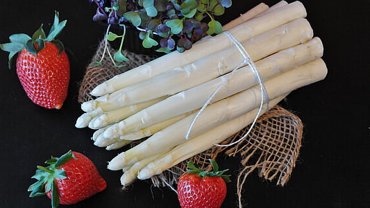 bundle of white vegetable beside three strawberries