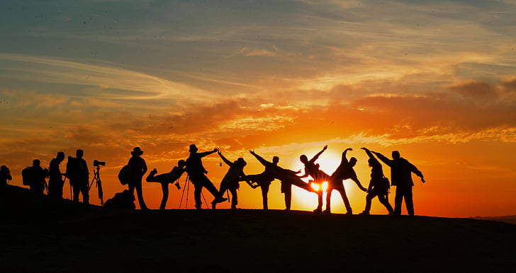 silhouette photograph of group of people during golden hour