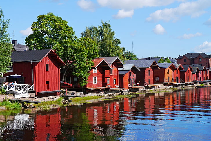 red and black wooden houses near water