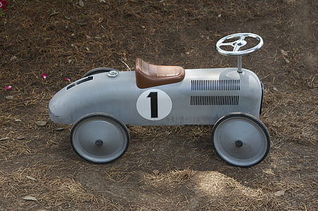 white and black ride-on car on brown soil