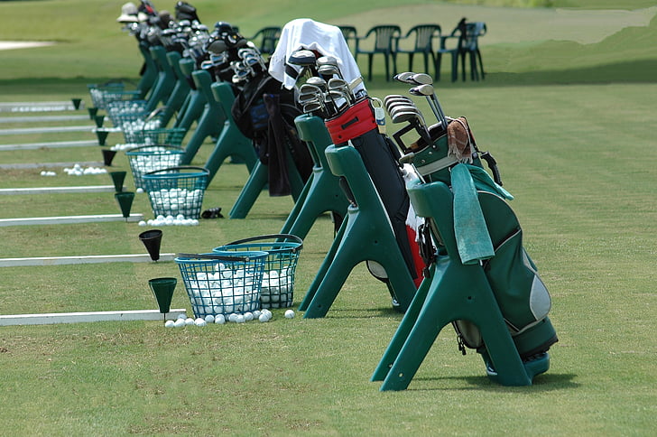 golf club in bags beside baskets on field