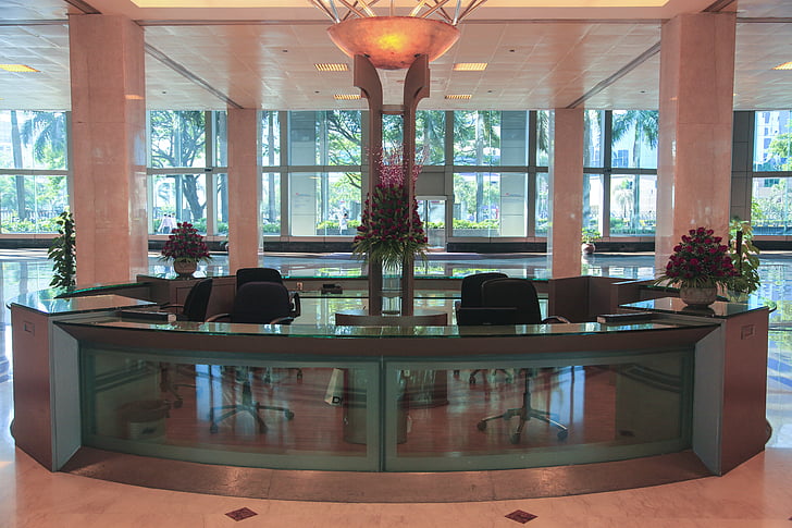 empty glass-top front desk in the lobby of a building