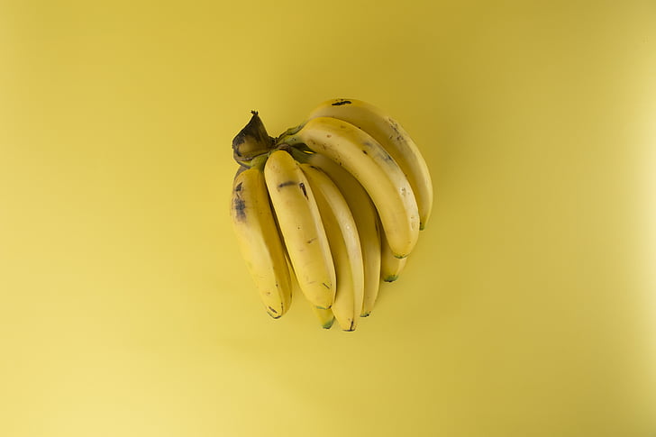 riped bananas on yellow surface