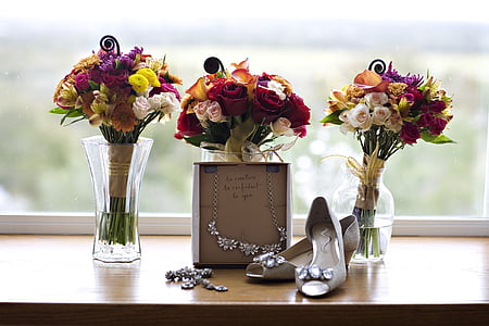 pair of beige heels beside three assorted vases