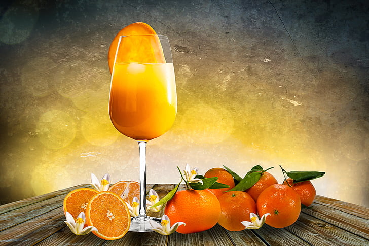 wine glass with orange juice on brown wooden table