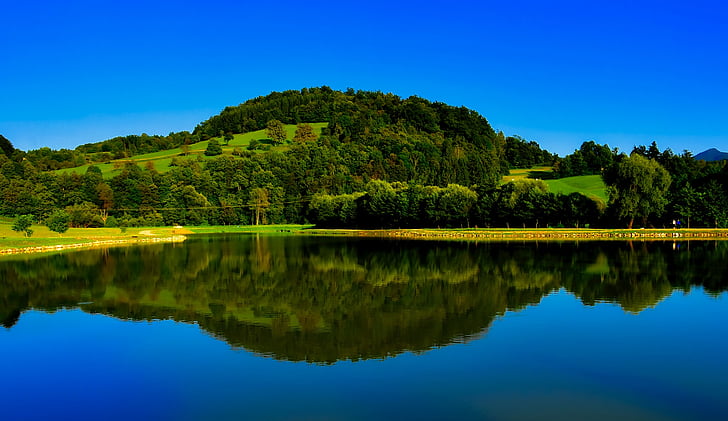 panoramic photography of hill with body of water