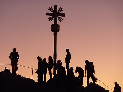 silhouette of brown wooden cross and people