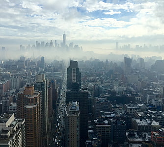 aerial photo of high-rise and low-rise buildings surrounded by fogs