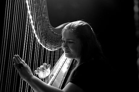 woman playing harp grayscale photo