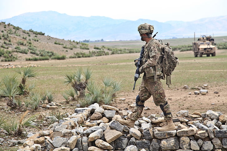 soldier holding assault rifle on gray and brown stones