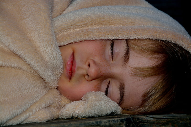 child sleeping with brown textile