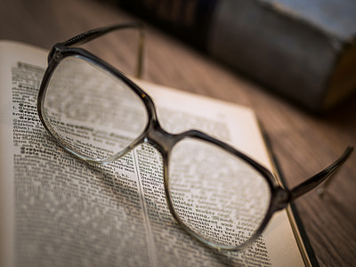 black framed eyeglasses on top of bookpage