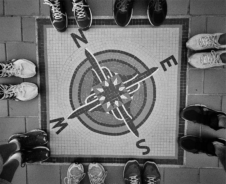 road painted with square compass surrounded by group of people wearing sneakers