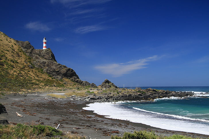 lighthouse on top of hill near seashore