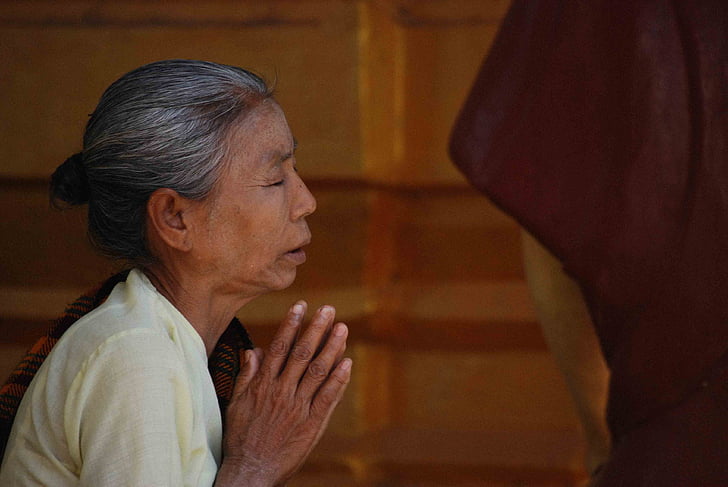 woman praying with close eyes during daytime