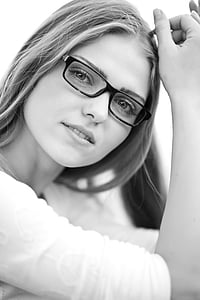 grayscale photo of woman wearing elbow-sleeved shirt and eyeglasses