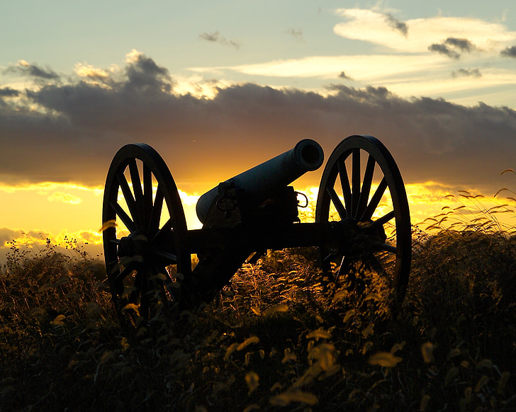 sihouette of antique cannon during sunset