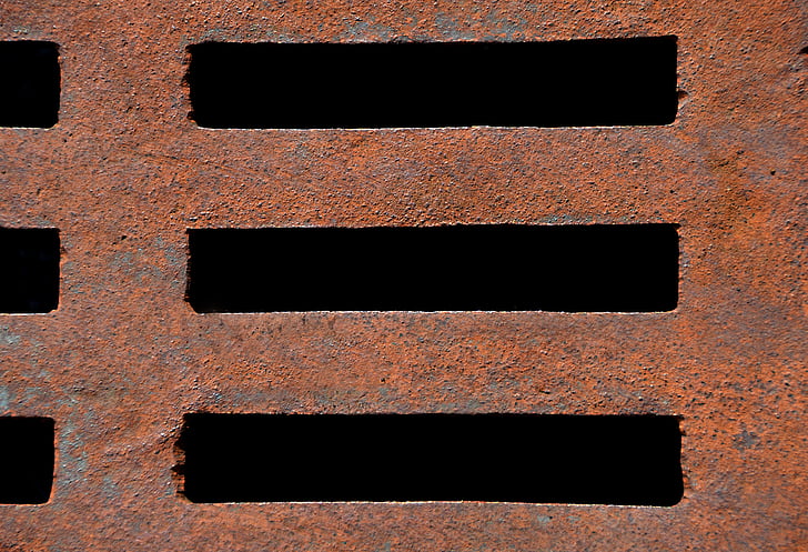 close-up photo of brown metal drainage