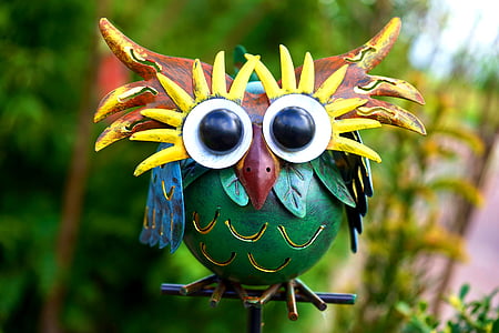 green and brown wooden owl figurine