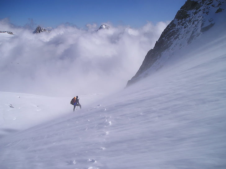 person climbing snowy mountain