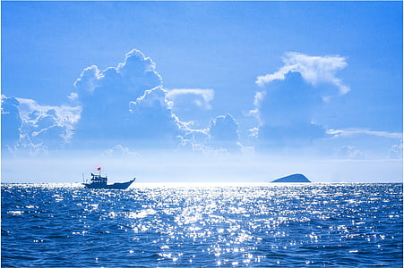 black vessel on body of water with blue sky background landscape photography