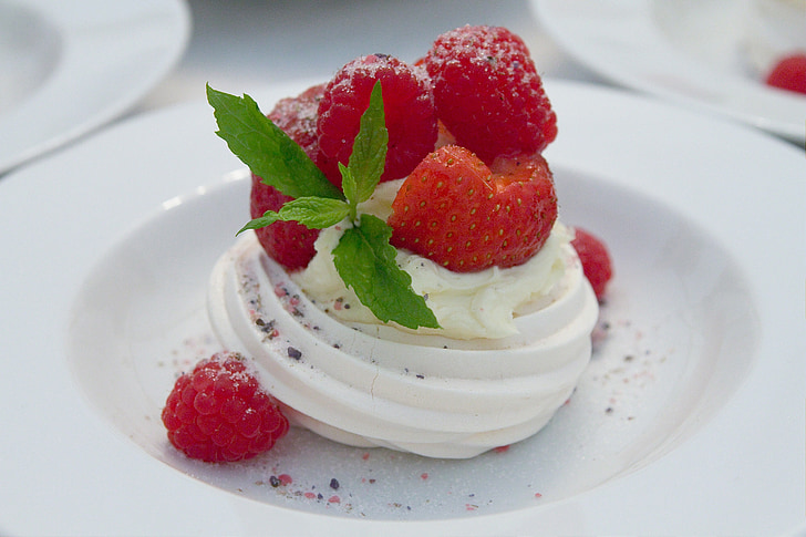 vanilla with strawberry and raspberry toppings on round white ceramic plate