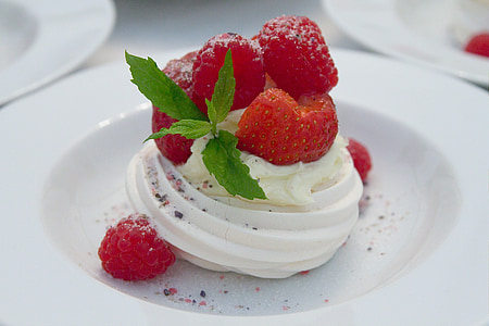 vanilla with strawberry and raspberry toppings on round white ceramic plate