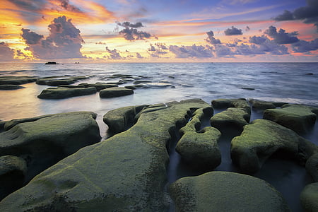 photography of gray boulder near seashore