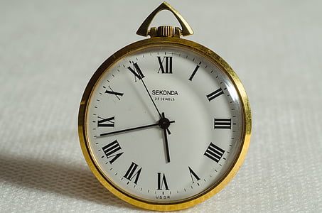 gold-colored pocket watch displaying 5:43