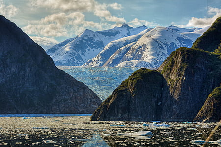 mountains and rock formations surrounded by body of water during daytime