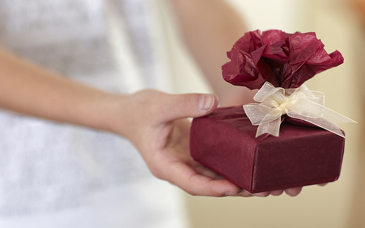 person holding maroon gift box