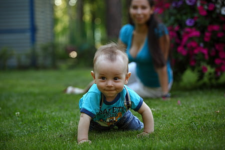 shallow focus photography of boy crawling on grass during daytime