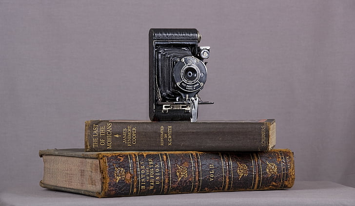 folding camera on top of brown book