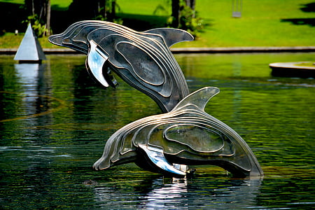 two statues of dolphins in water