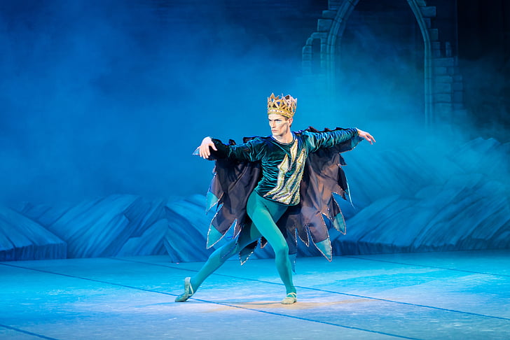 man wearing crown performing on stage