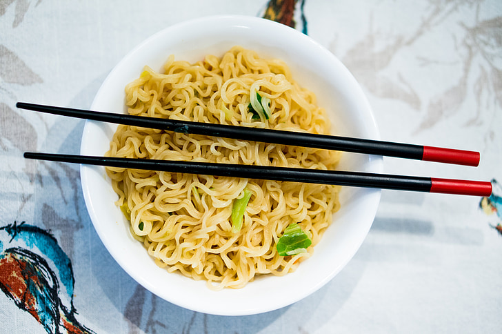 noodles in white ceramic bowl and black chopsticks