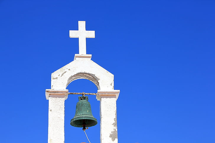 black bell mounted on cross