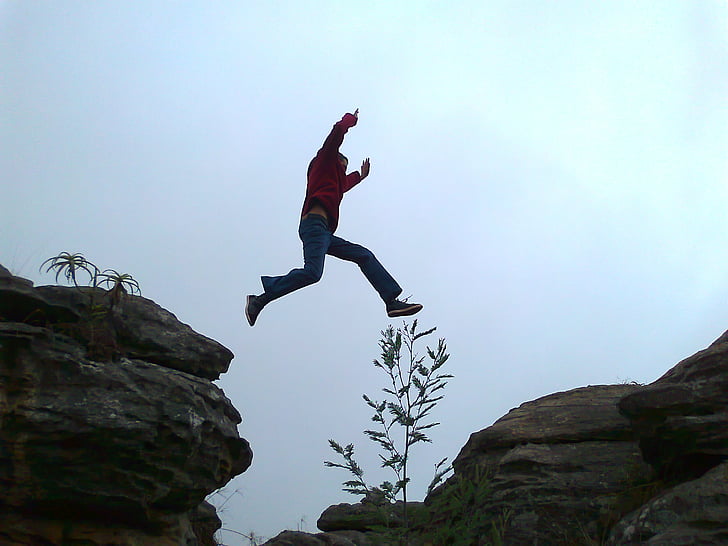 man jumping on rock