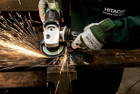 person using angle grinder on steel