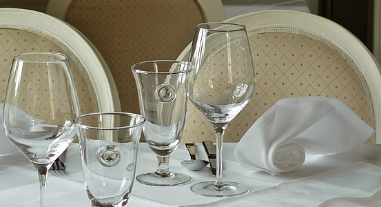 four wine glasses on white table curtain close-up photo