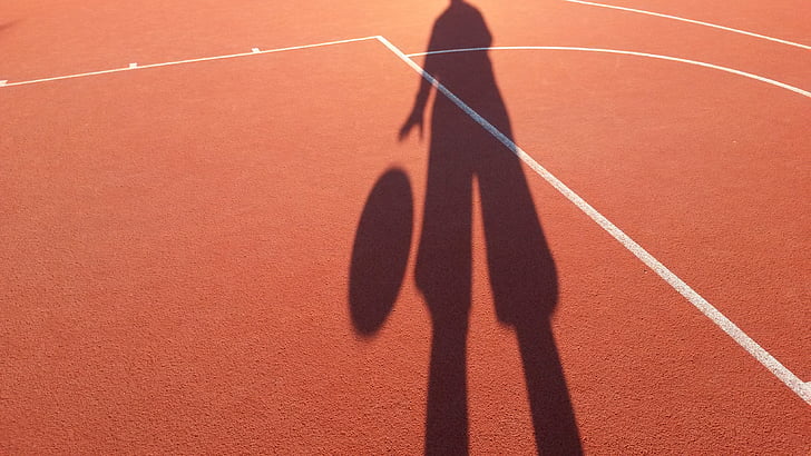 silhouette of person dribbling a ball