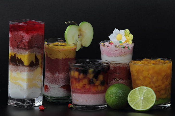five assorted deserts on clear glass cups