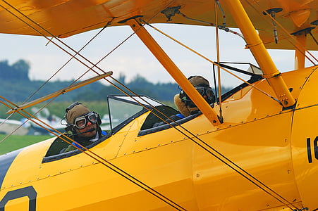 two men on yellow aircraft during daytime