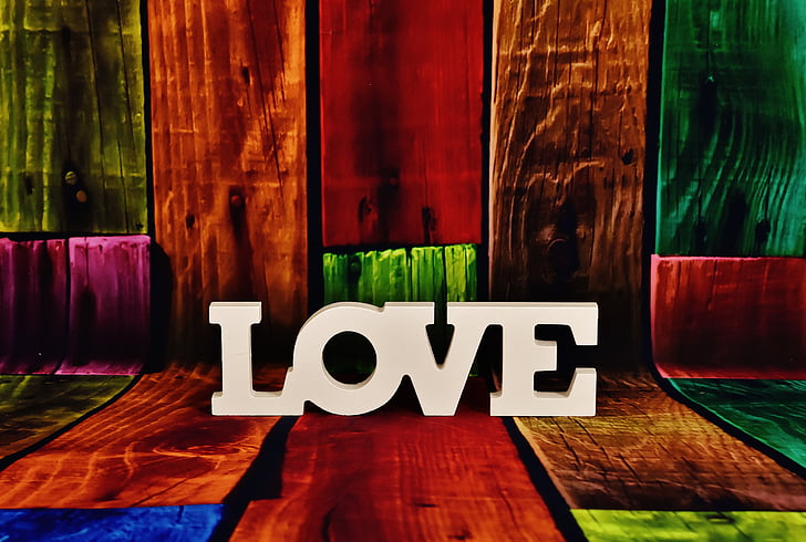 white LOVE freestanding letters on multicolored wood planks