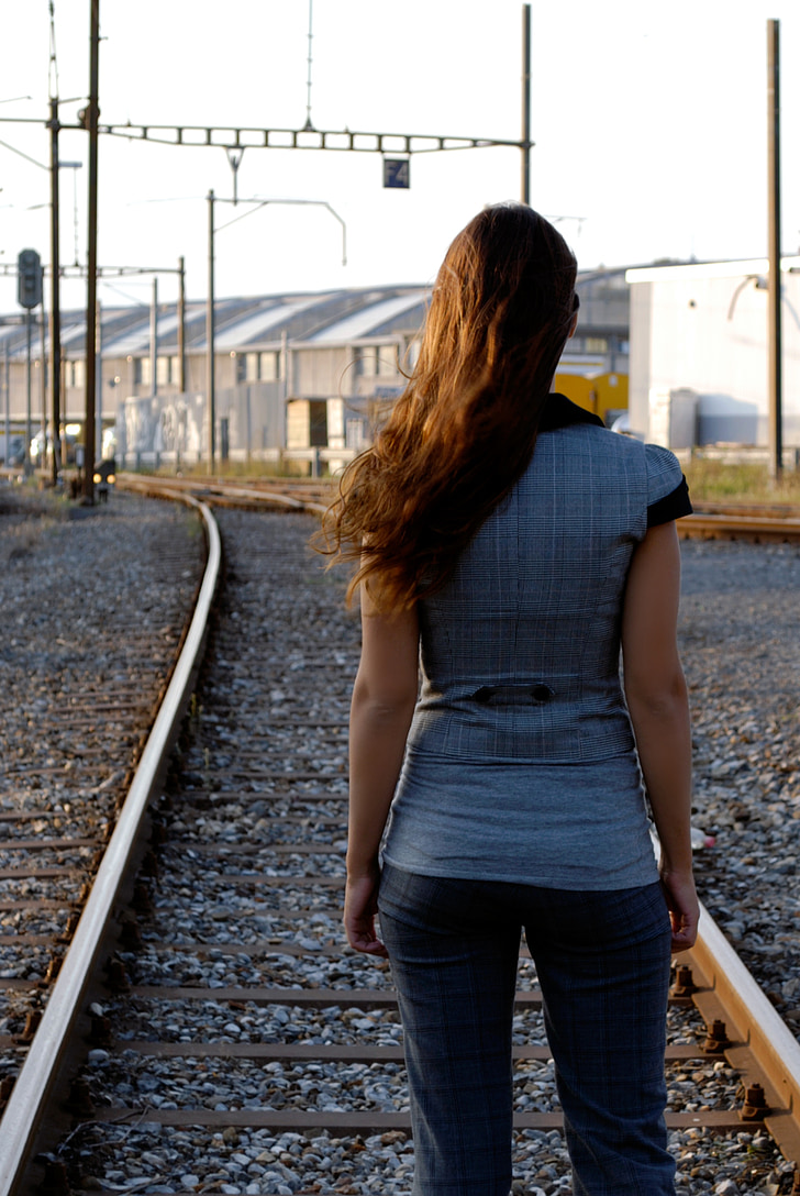 woman standing on train rail