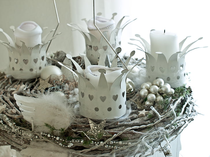 four white crown candle holders on gray nest