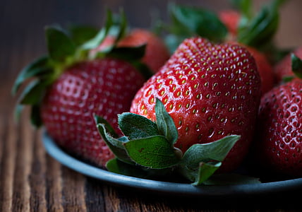 macro photography of strawberries on top of gray plate