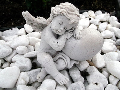white cherub statue on white rocks