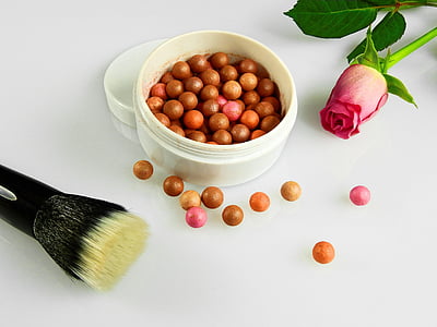 bowl of beads beside red rose