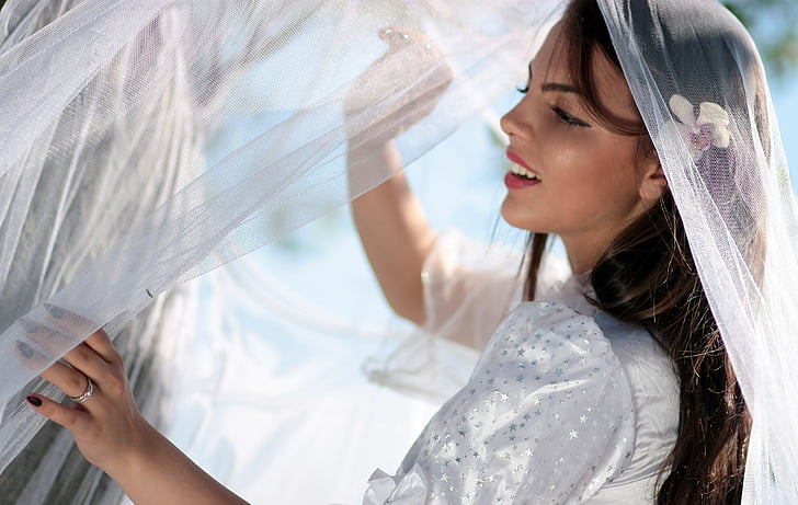 woman wearing white dress holding veil